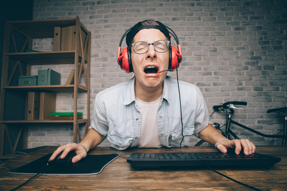 man with headset crying at computer