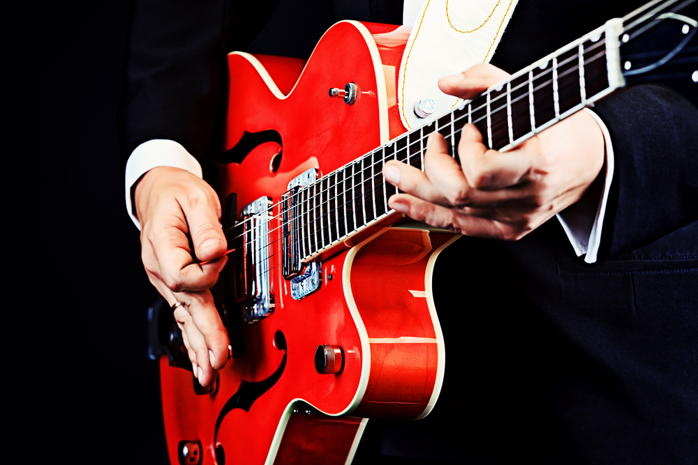 red semi-acoustic guitar being played